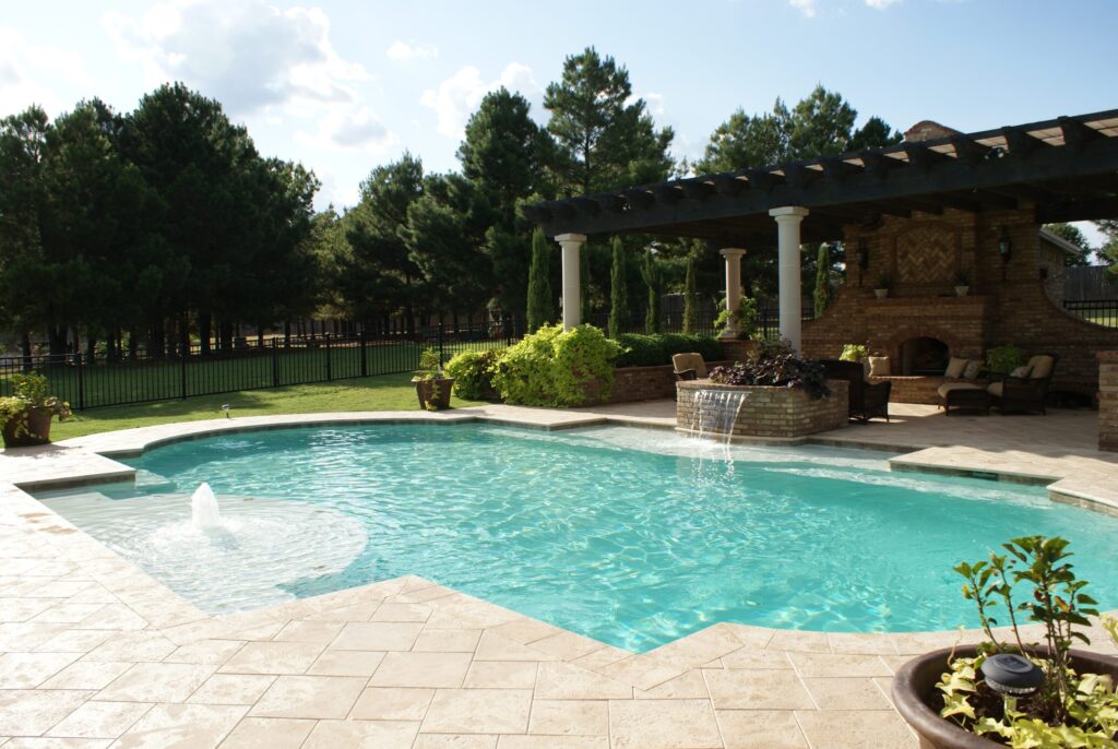 Outdoor Pool and spa along with a luxurious outdoor patio with custom brick fireplace located in Southlake, TX.